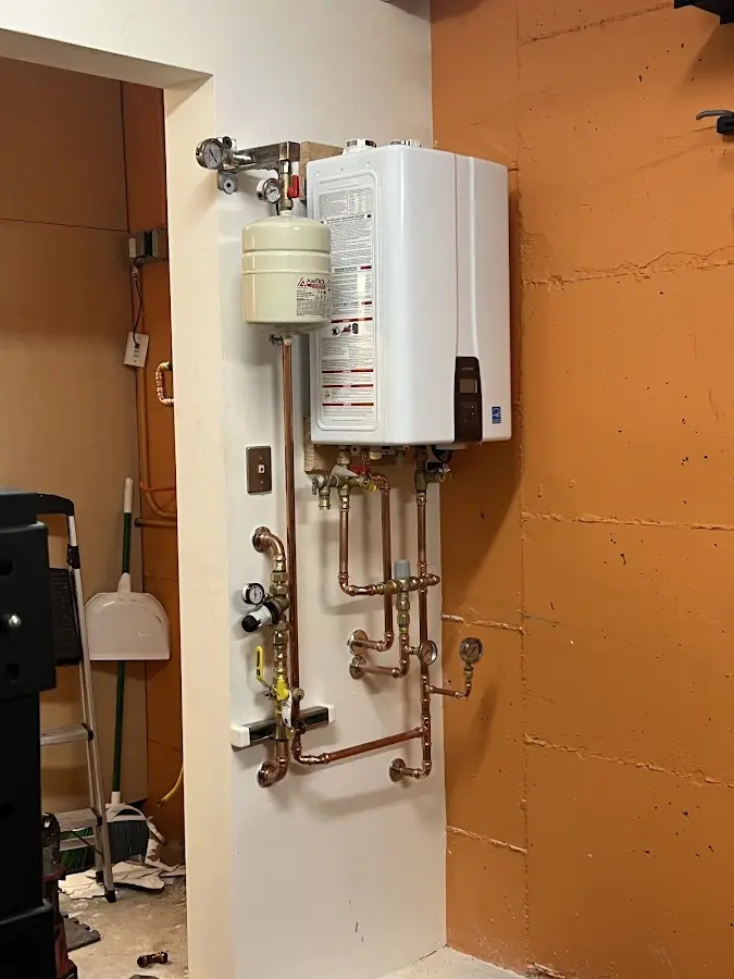 Plumbing technician inspecting water heater connections in Macungie